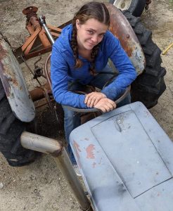 Jennifer Sales on a grading tractor